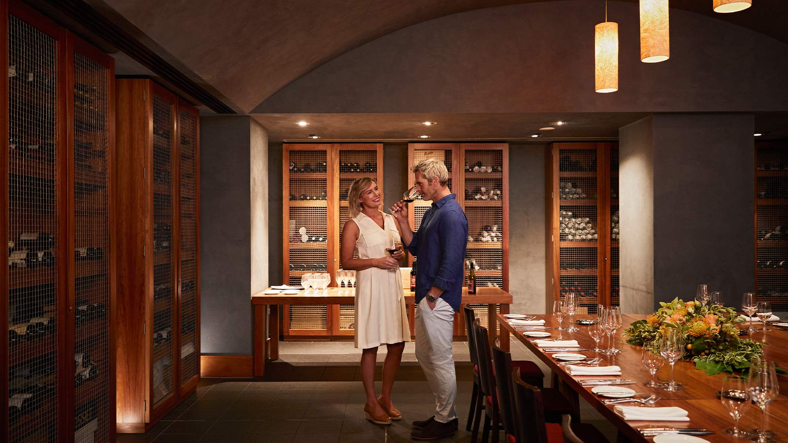 Couple drinking wine in the wine cellar private dining space.