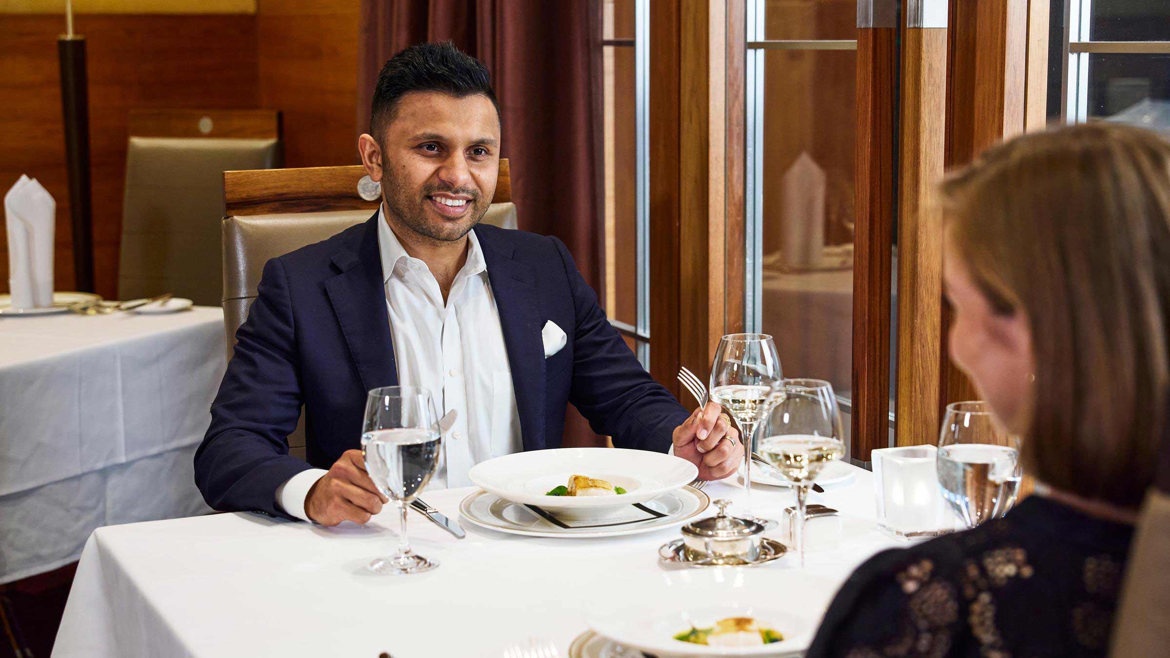 A couple dining at a table covered with a white tablecloth at RACV City Club's Members Lounge.