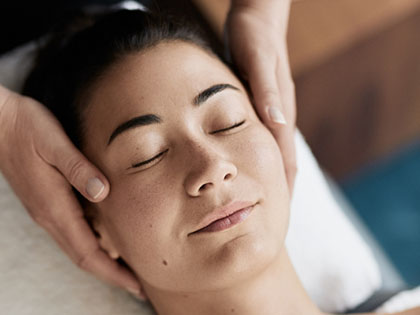 Woman with eyes closed getting a facial.