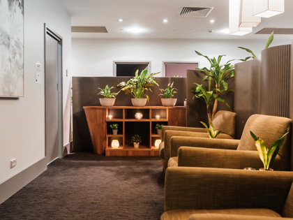 Relaxation lounge at One Spa City Club decorated with plants and candles