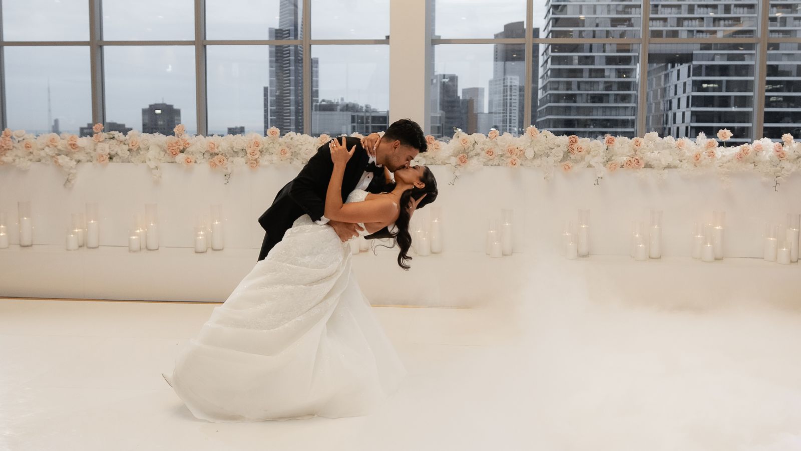 Couple dancing together at their wedding with the city skyline in the background