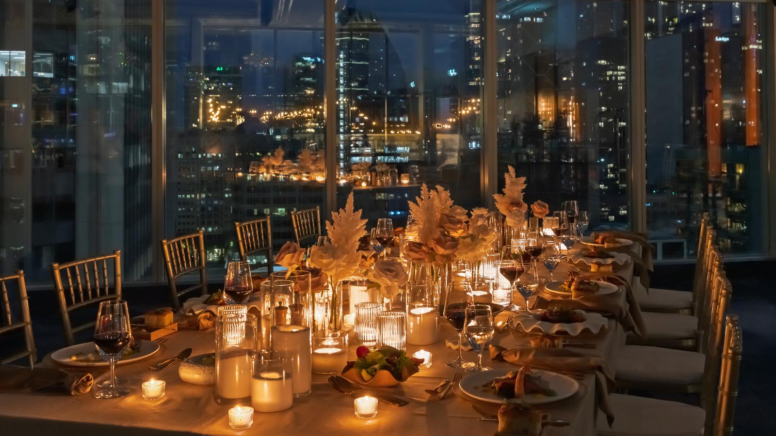 Table set for a wedding with mood lighting and the city in the background