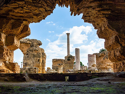 Ancient ruins against a partly cloudy sky.
