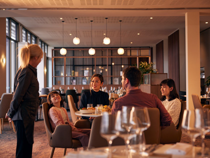A family dining in Banyalla restaurant with the waiter standing by the table
