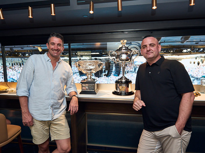 Two club members posing in front of the Australian Open trophy
