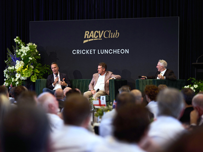 A crowd watching people on stage for a talk on cricket