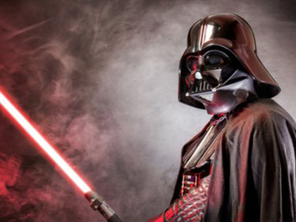 Darth Vadar brandishing a red light saber with smoke in the background.