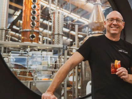 Man standing next to a window into the Four Pillars Gin Distillery.