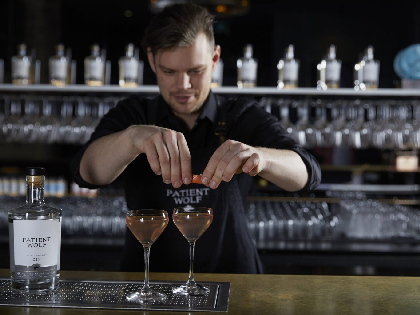 A bartender making some cocktails in martini glasses
