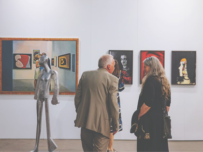 People admiring artwork in a gallery.