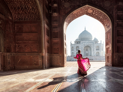 A woman dressed in pink in a temple in India 