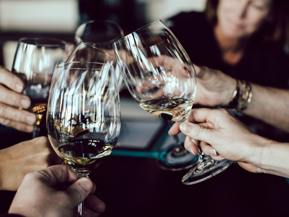 Several hands cheersing wine glasses