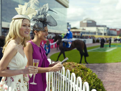 Two women watching a horse race during the spring racing carnival