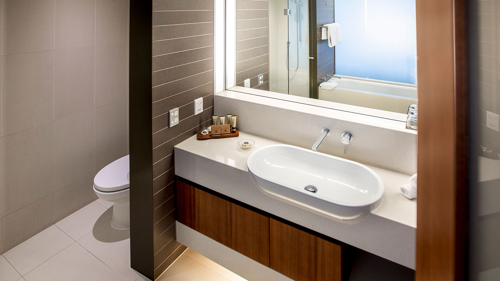 Bathroom in Lawn View Room at RACV Healesville Country Club and Resort, featuring toiletries, a large sink and mirror, and toilet.