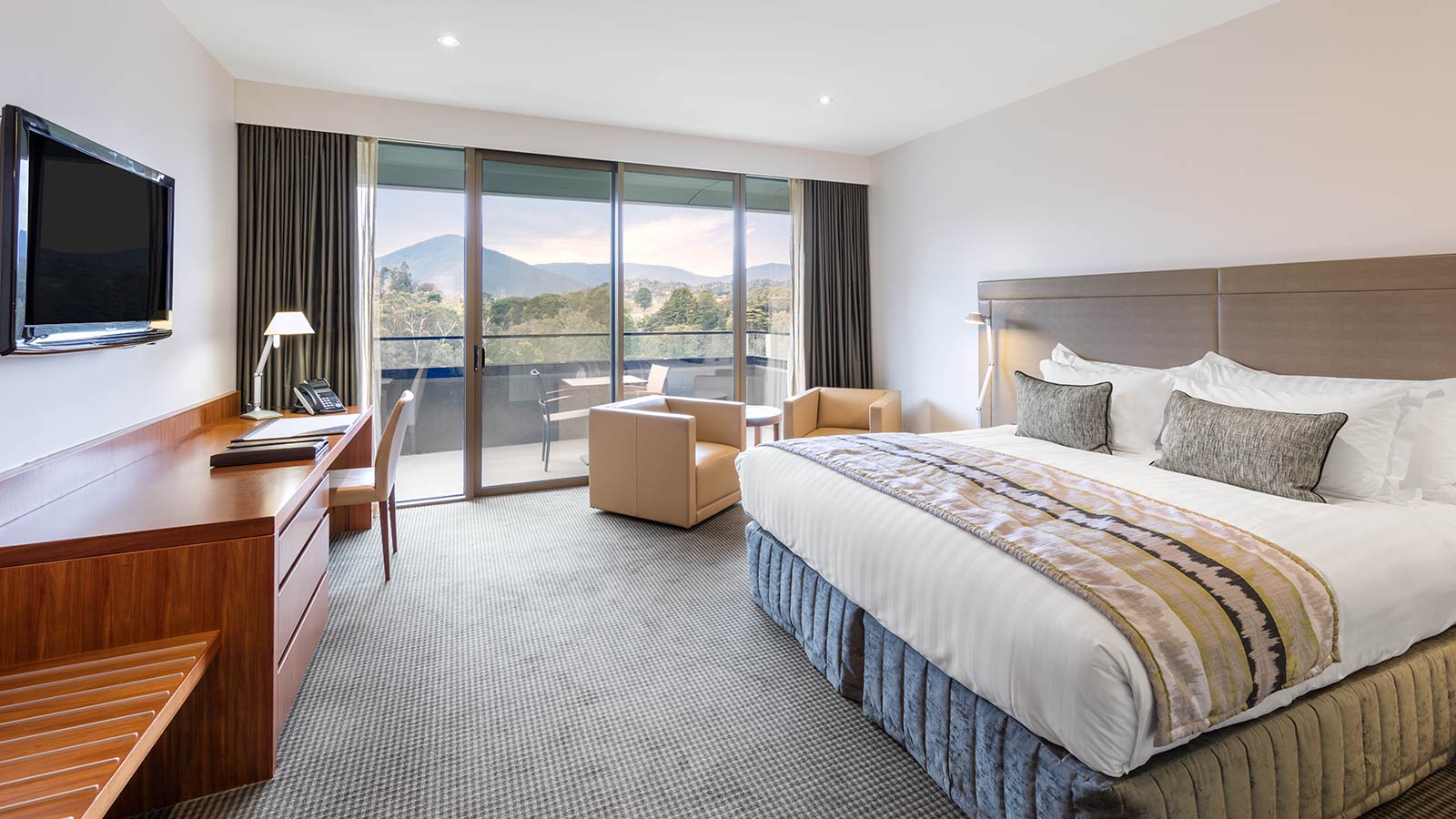 Mountain View Room at RACV Healesville Country Club and Resort, featuring a king bed, TV, desk, couches and balcony.
