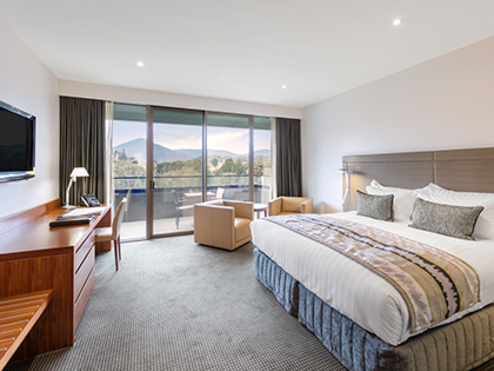 Mountain View Room at RACV Healesville Country Club and Resort, featuring a king bed, TV, desk, couches and balcony.