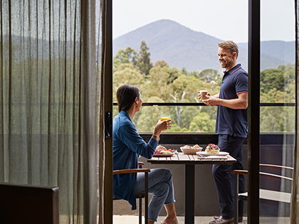 A couple enjoying breakfast on the balcony of their room at RACV Healesville Country Club and Resort.