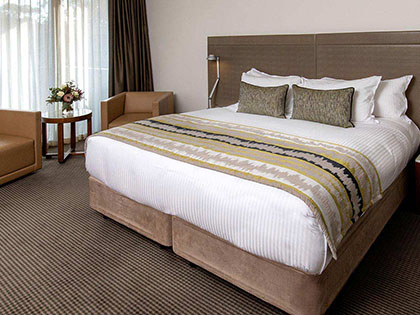 Large bed with chairs and bedside table