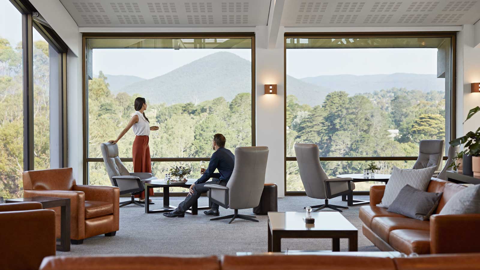 A couple relaxing and enjoying the view of Mt Riddell in the Members lounge. 