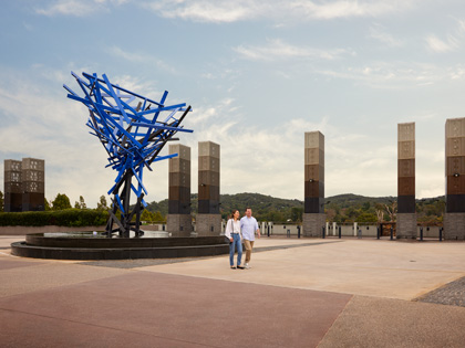 A couple walking into the club with a blue abstract sculpture behind them. 