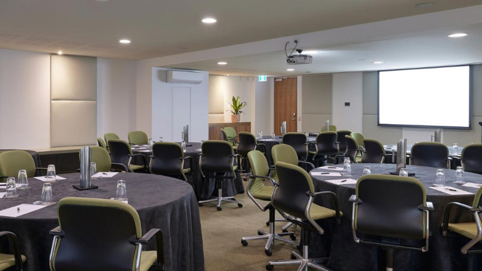 Barak conference room set with circular tables and a screen.