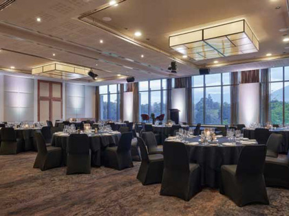 Ballroom decorated with black tables and chairs banquet style.