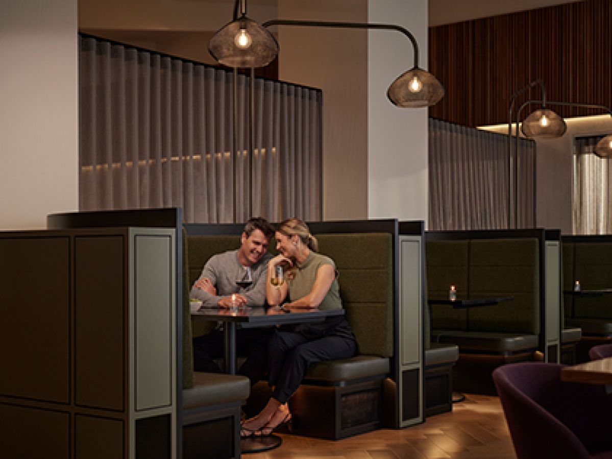 Two people sitting in a booth and drinking wine together at Banyalla, RACV Healesville Country Club and Resort.