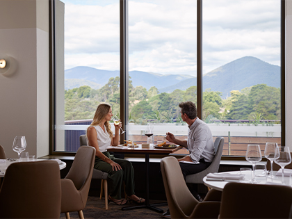 A couple enjoying the view from the dining area of Banyalla restaurant, Healesville Country Club.