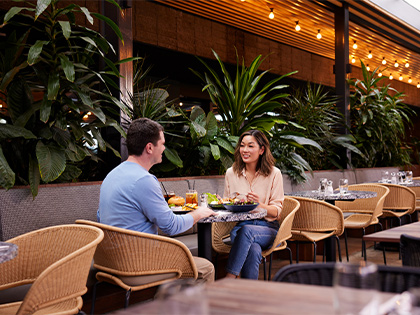 Two people sharing a meal at Riddell's Green restaurant at RACV Healesville Country Club and Resort.