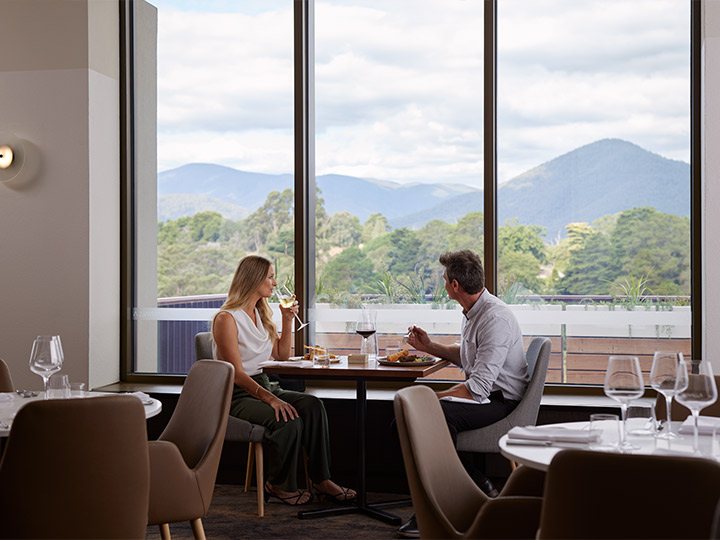 A couple enjoying the view from the dining area of Banyalla restaurant, Healesville Country Club.