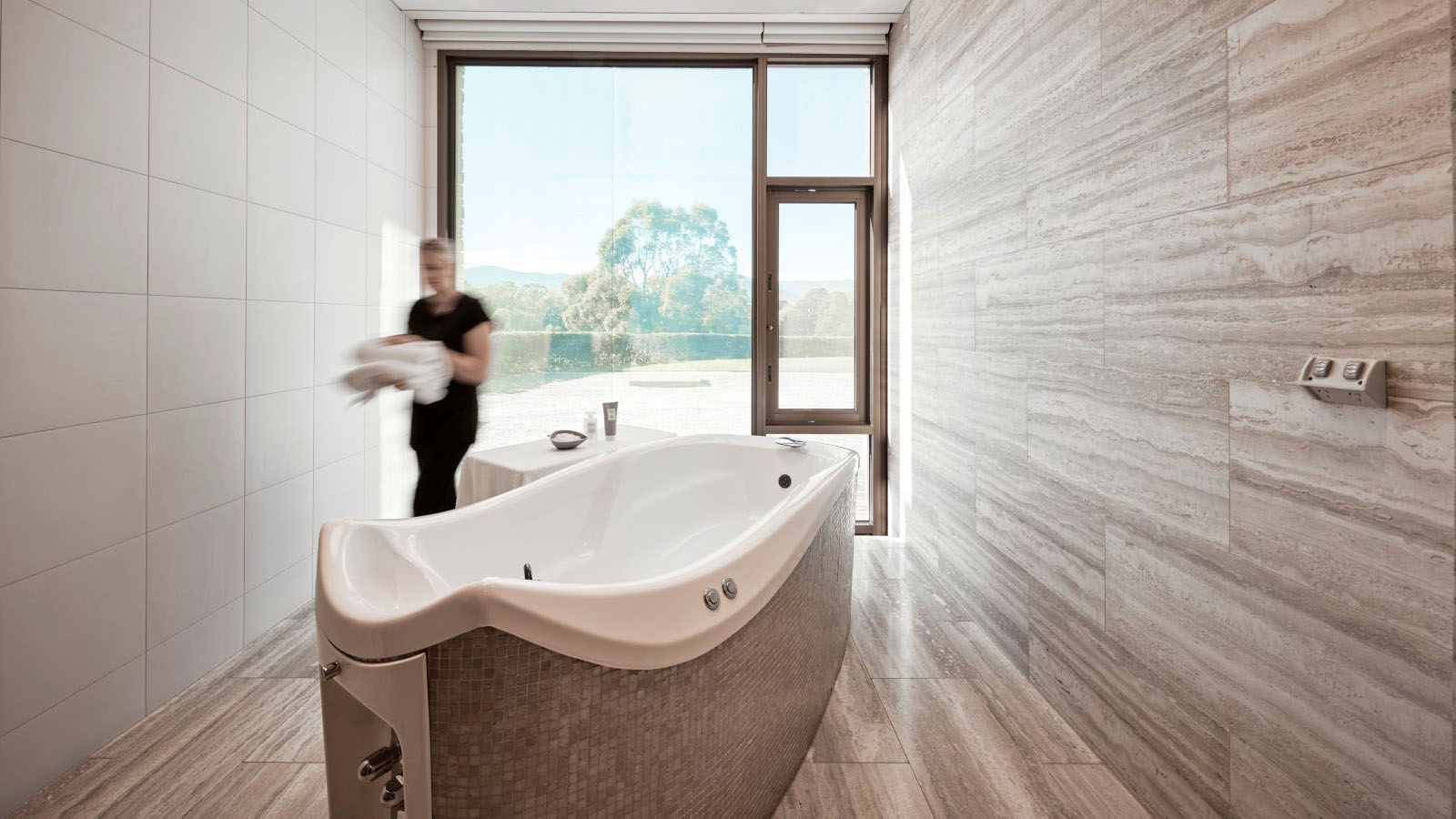 An employee of the Healesville One Spa preparing a treatment room for use.