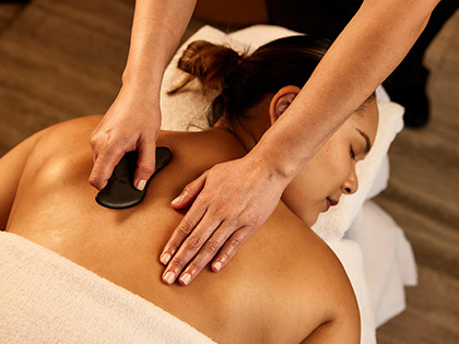 A massage therapist using specialist tools at the Healesville, One Spa.