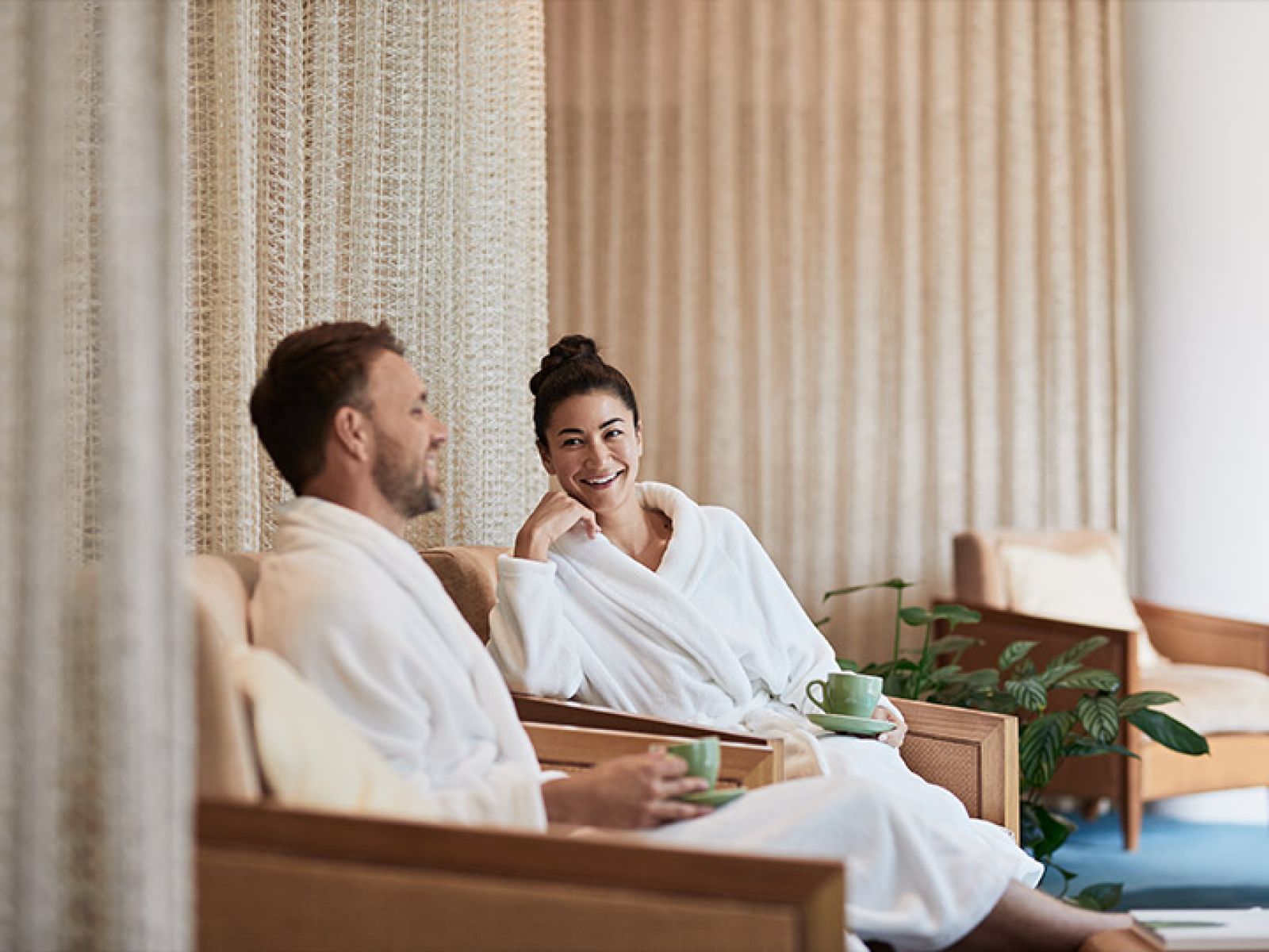 Couple sitting in bathrobes and drinking tea at the RACV Healesville Country Club & Resort's One Spa lounge.