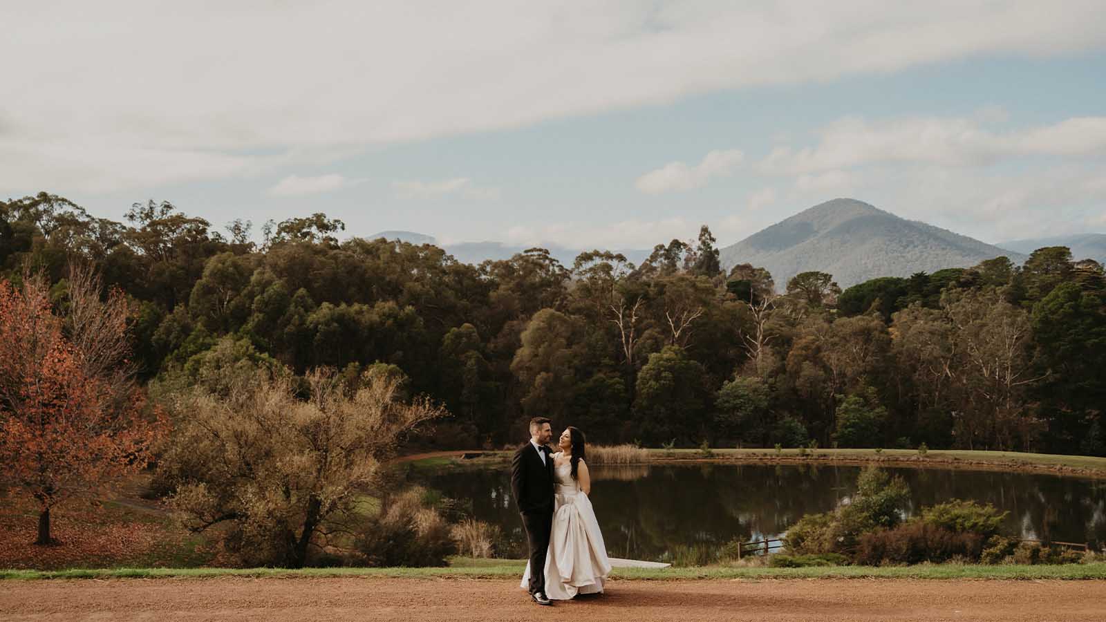 Bride and groom posing in front of Mt Riddell at Healesville Country Club and Resort.