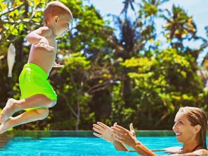 A mother and child playing in a pool on a sunny day in Bali