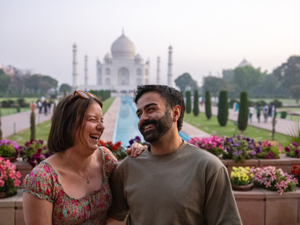 A couple laughing infront of the Taj Mahal