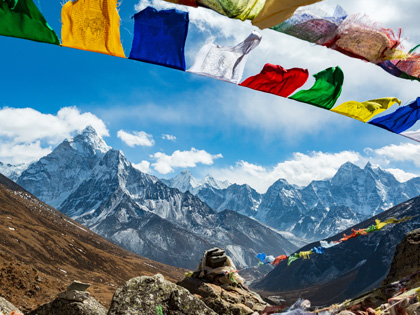 Everest base camp with stones and Nepalese prayer flags, on the horizon of the mountain.