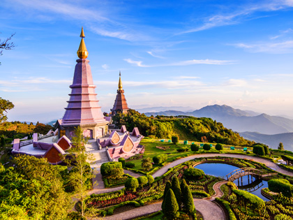 Pink temple and gardens in mountain ranges of Thailand.