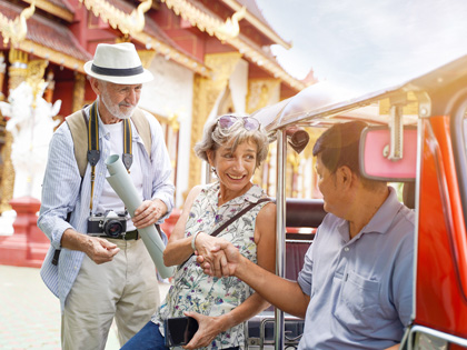Woman shakes tour guides hand as they sit in a tuktuk