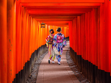 Two women in Japanese clothing walking through a temple