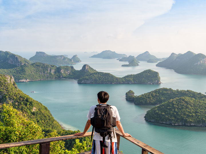 Man overlooking a peak of small islands and water