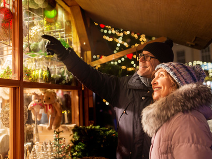 Elderly couple looking at christmas decorations in a window