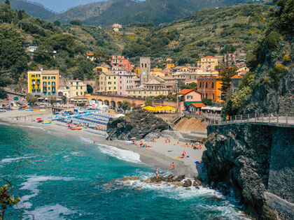 A beachside European town with rocky cliffs on a sunny day.