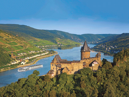 An old castle on the edge of water surrounded by trees in Europe. 