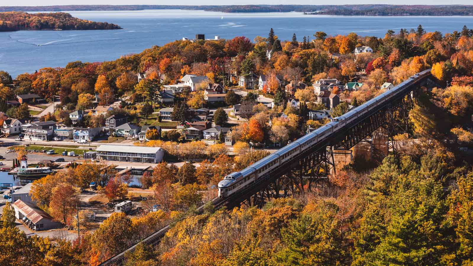 Long train moving overhead a small town in Canada during Autumn