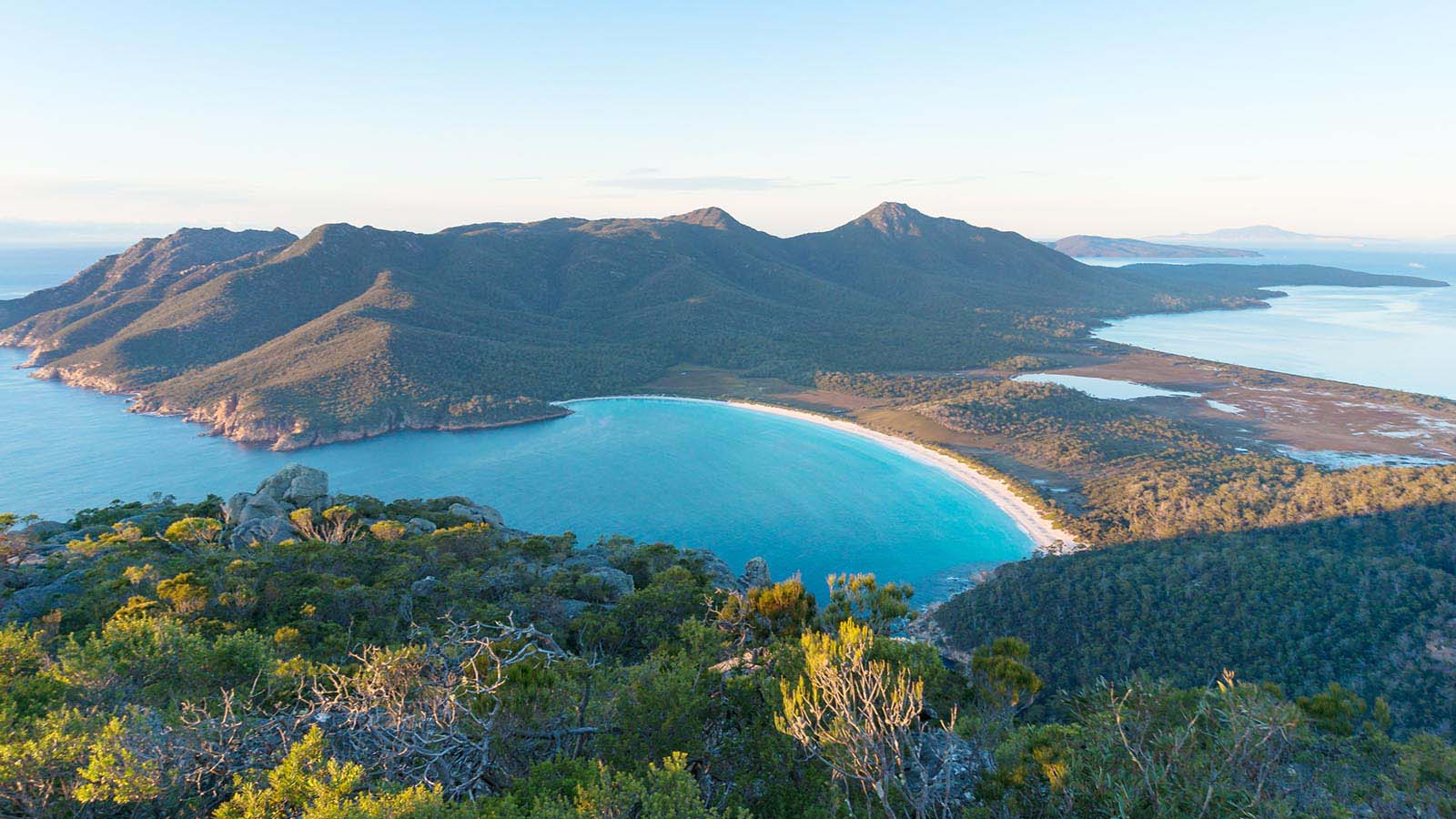 Aerial view of Tasmanian beach and mountains.