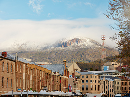 Building-lined street in Hobart, with a mountain in the distance.