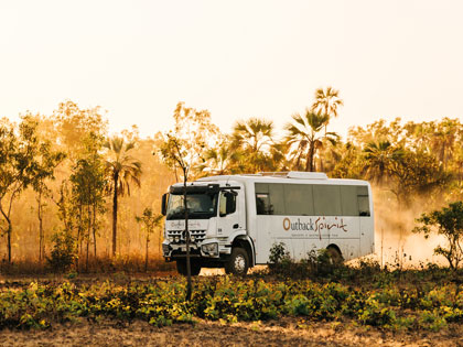 Outback Spirit bus driving through the kimberleys at dusk. 