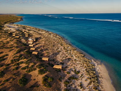 Aerial view of some huts lining the australian coastline.