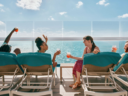 Four frineds enjoying a drink on thebalcony of a cruise ship. 